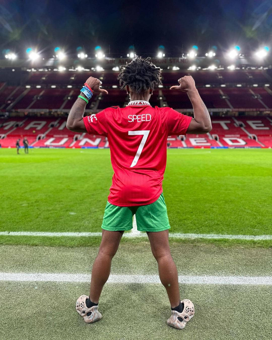 A Man In A Red Shirt Standing On A Soccer Field