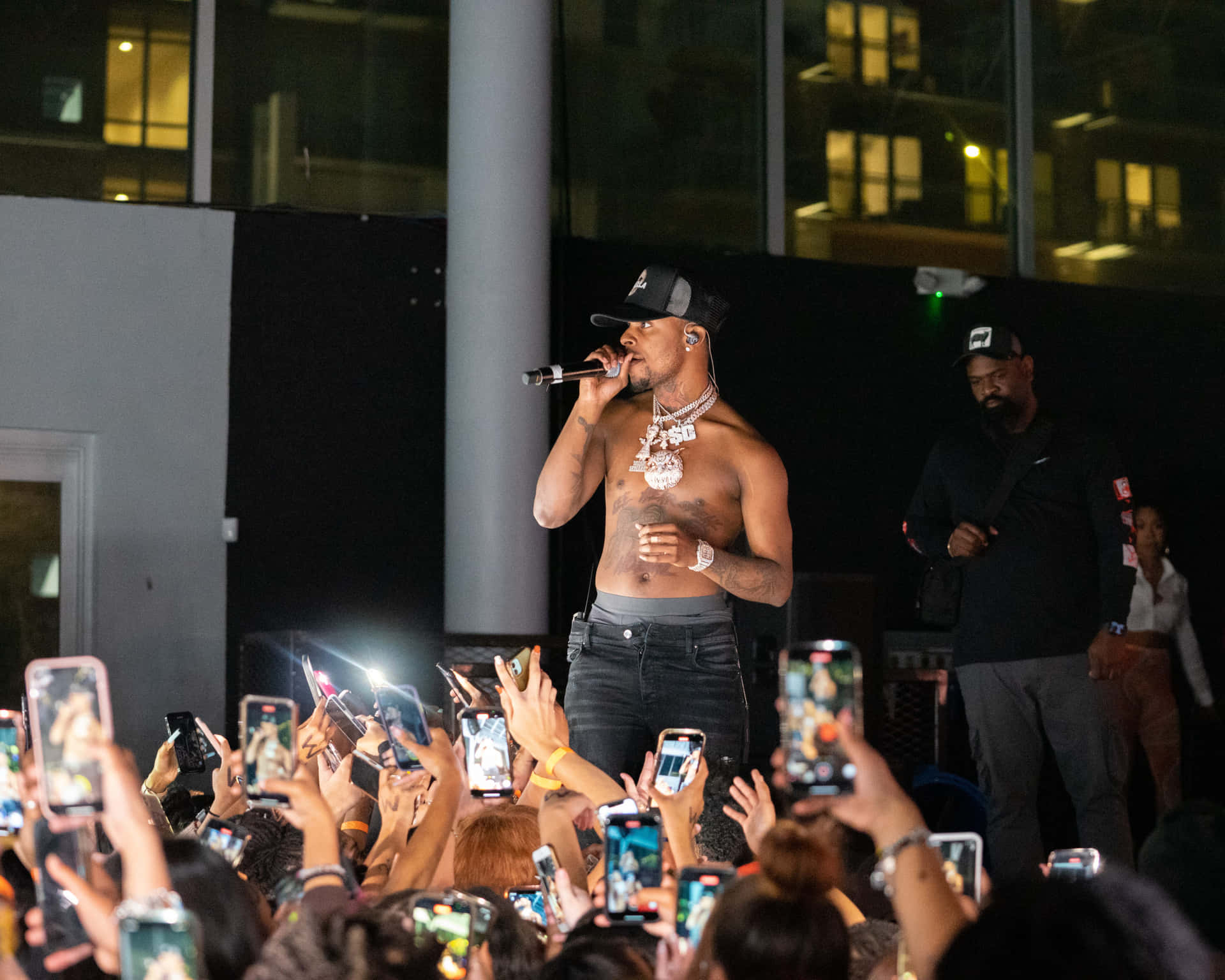 A Man In A Shirt Is Standing In Front Of A Crowd Background