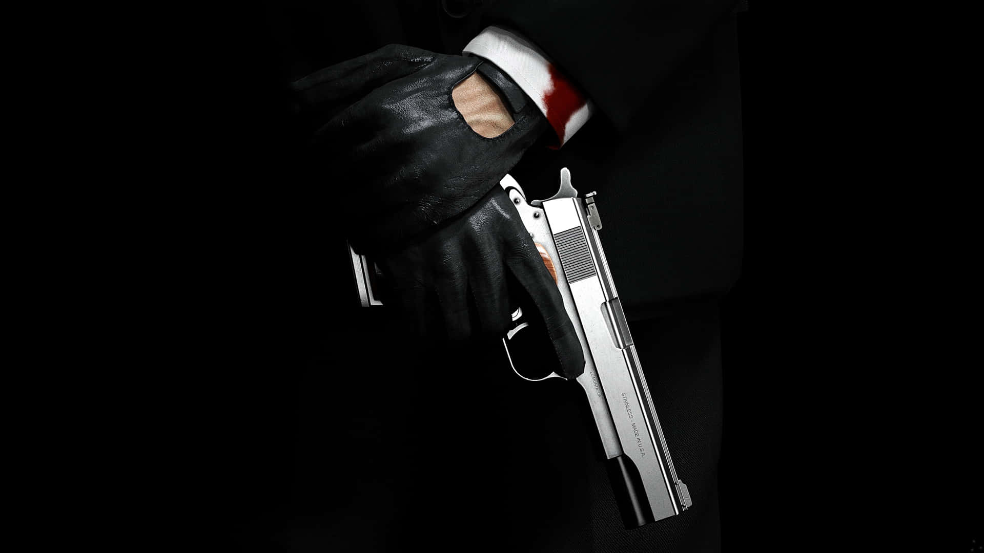 A Man In A Suit Holding A Gun Background