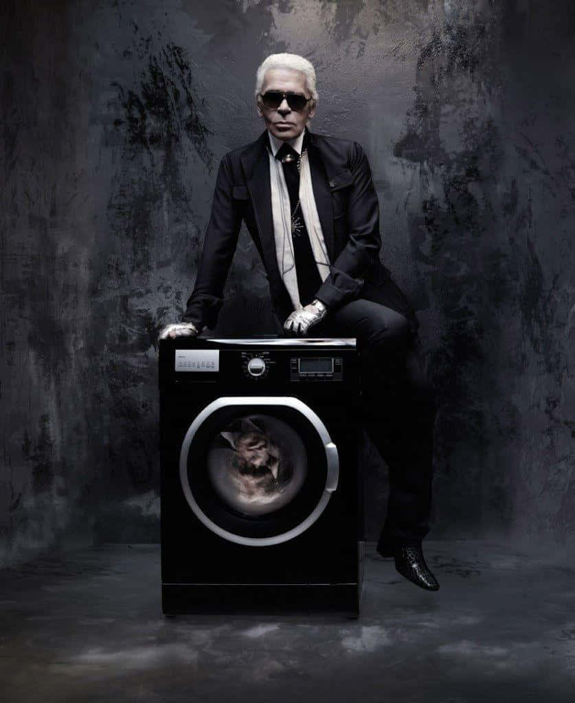 A Man In A Suit Sitting On A Washing Machine Background