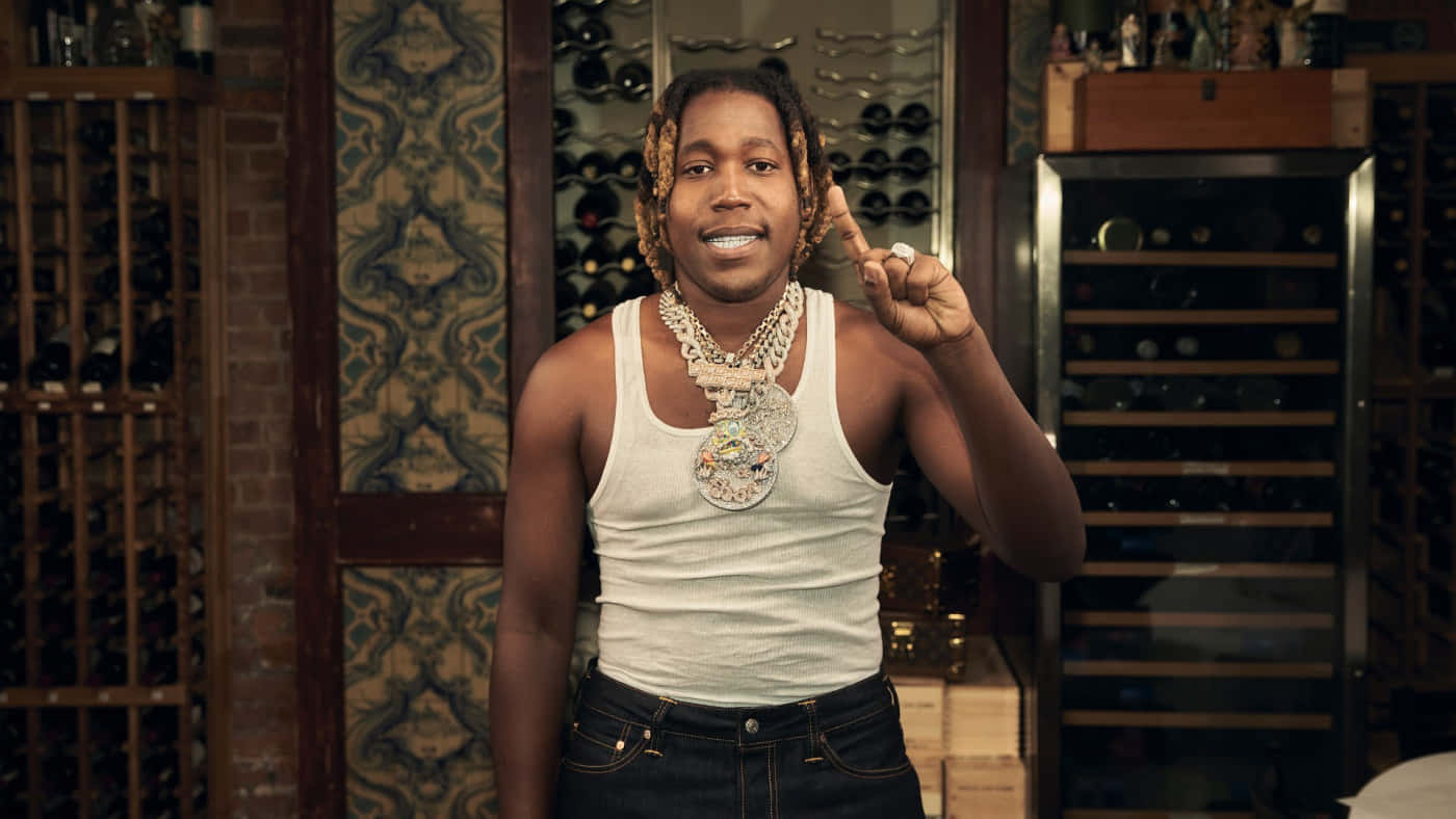 A Man In A Tank Top Standing In A Room With Wine Bottles Background