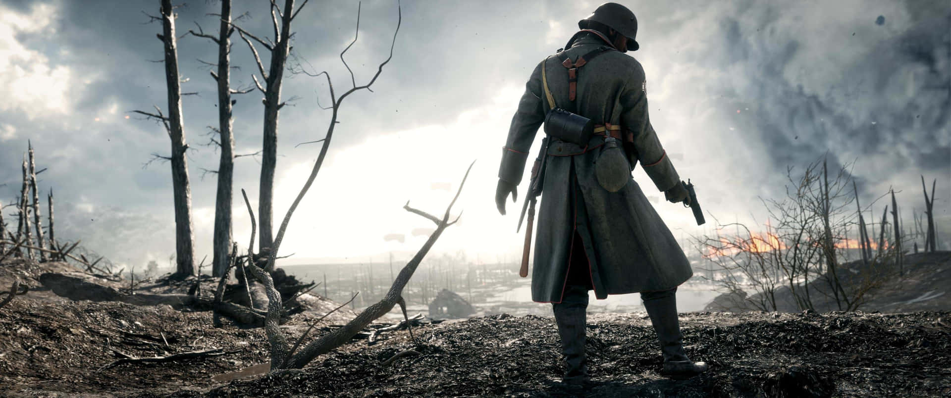 A Man In A Trench Coat Is Standing In Front Of A Fire Background