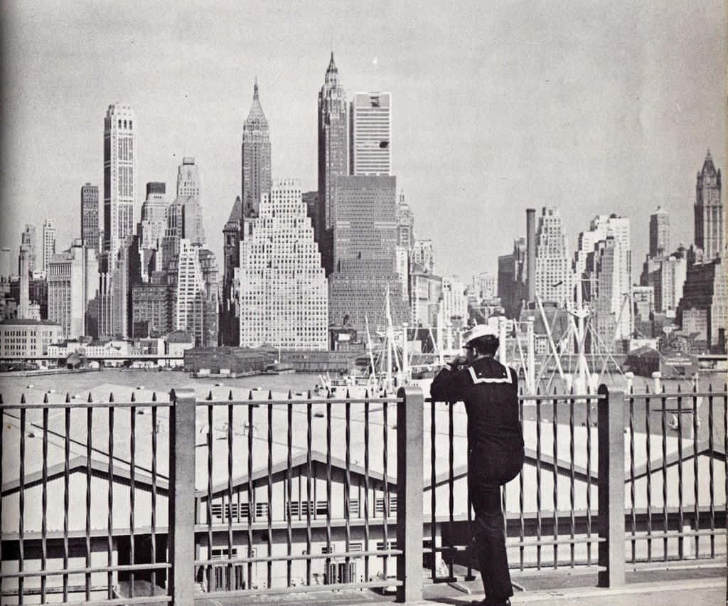 A Man In A Uniform Looking Out Over The City Background
