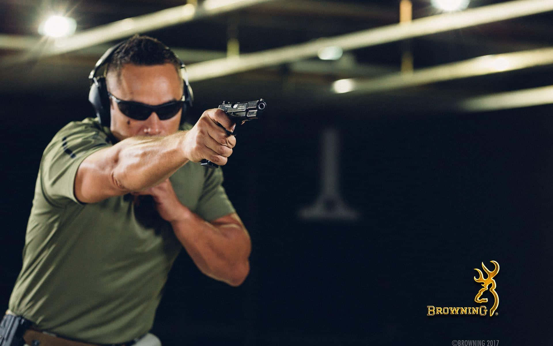 A Man In Sunglasses Is Holding A Gun Background