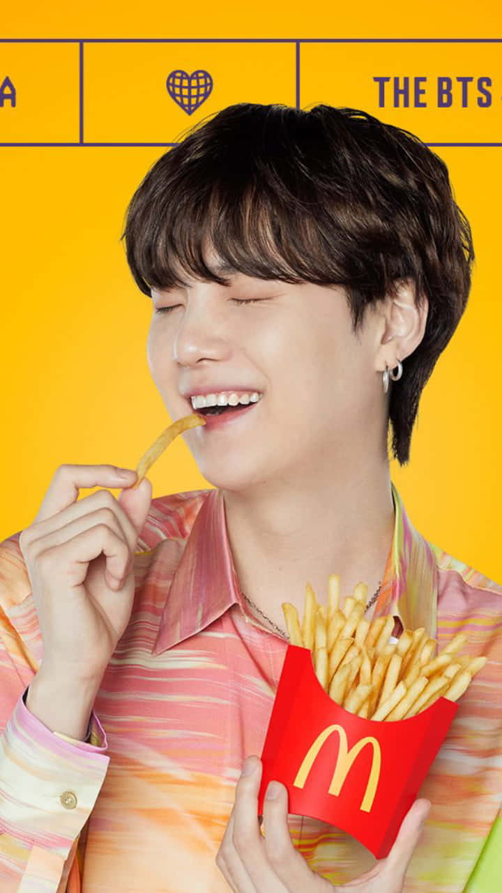 A Man Is Eating French Fries With A Bts Shirt Background