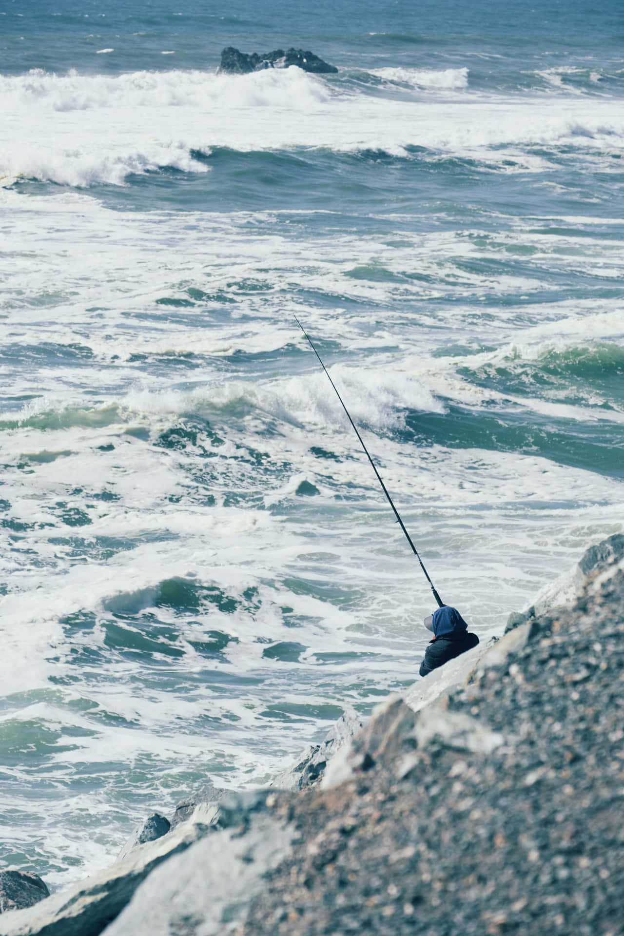 A Man Is Fishing Off The Coast