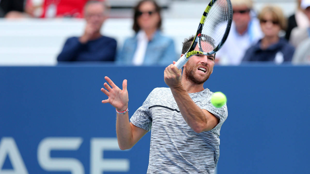 A Man Is Hitting A Tennis Ball