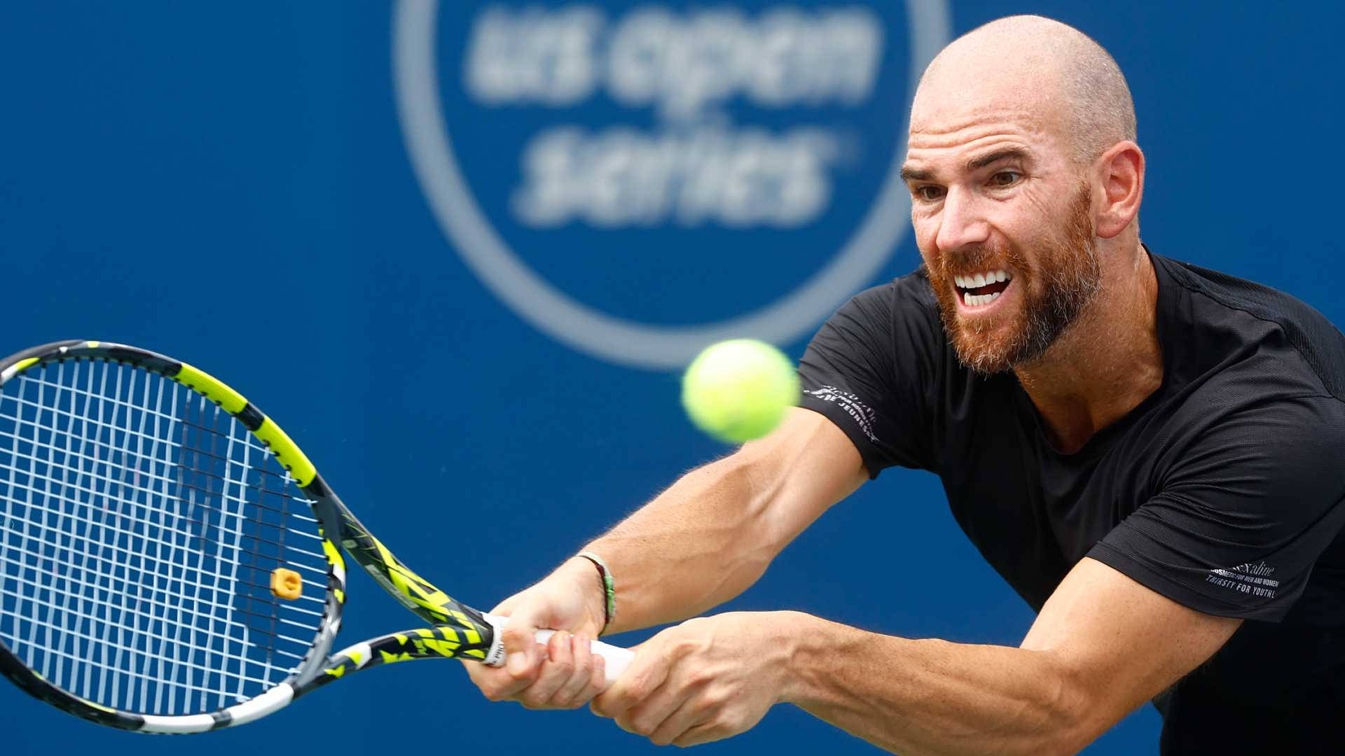 A Man Is Hitting A Tennis Ball With His Racket