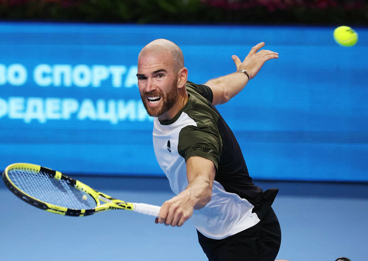 A Man Is Hitting A Tennis Ball With His Racket