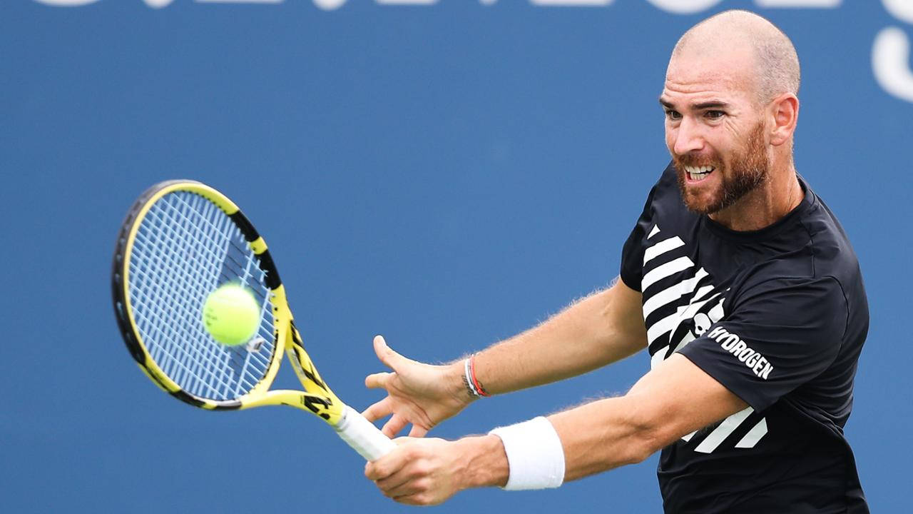 A Man Is Hitting A Tennis Ball With His Racket Background