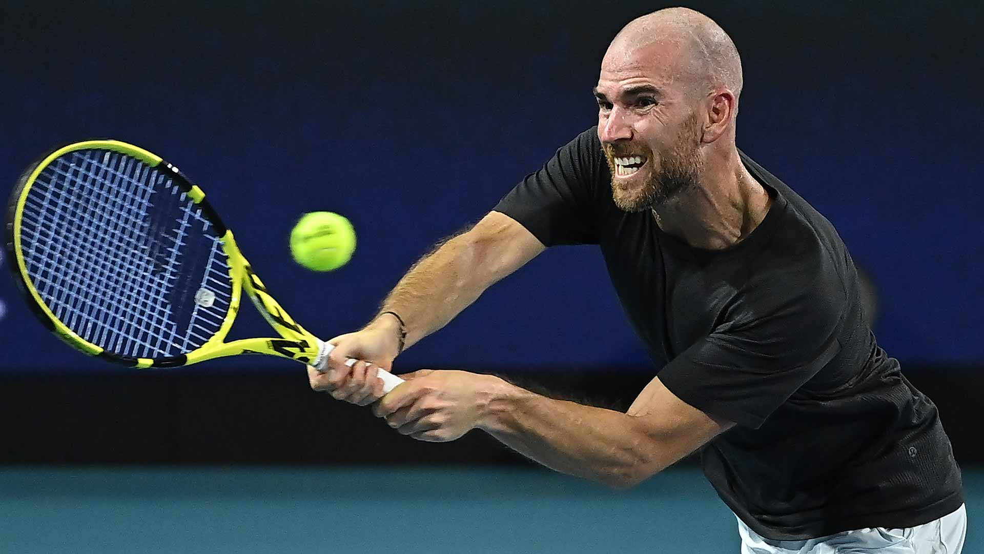 A Man Is Hitting A Tennis Ball With His Racket Background