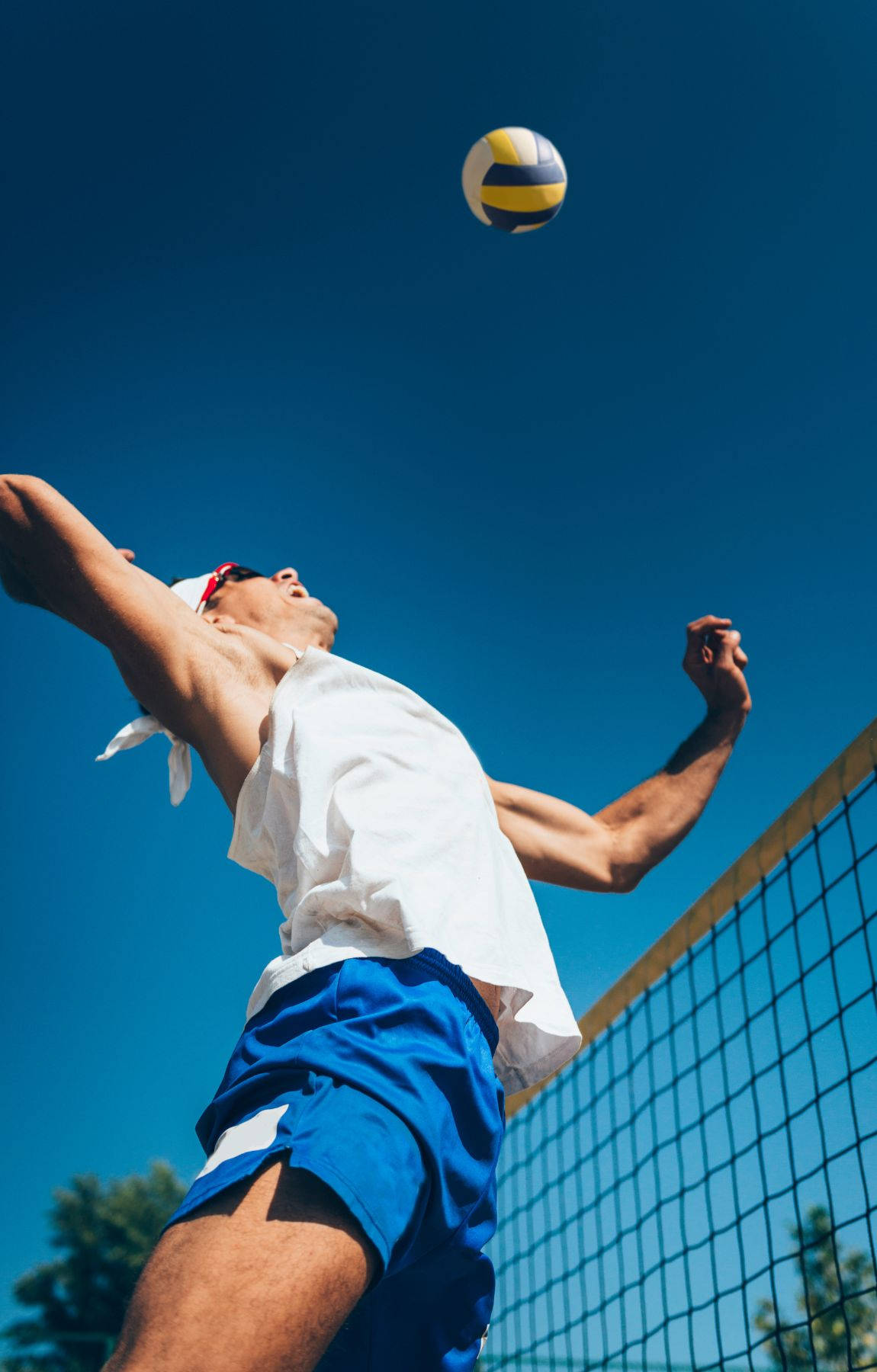 A Man Is Hitting A Volleyball Ball Background