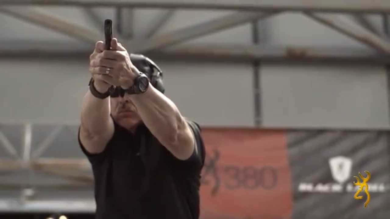 A Man Is Holding A Gun In His Hand Background