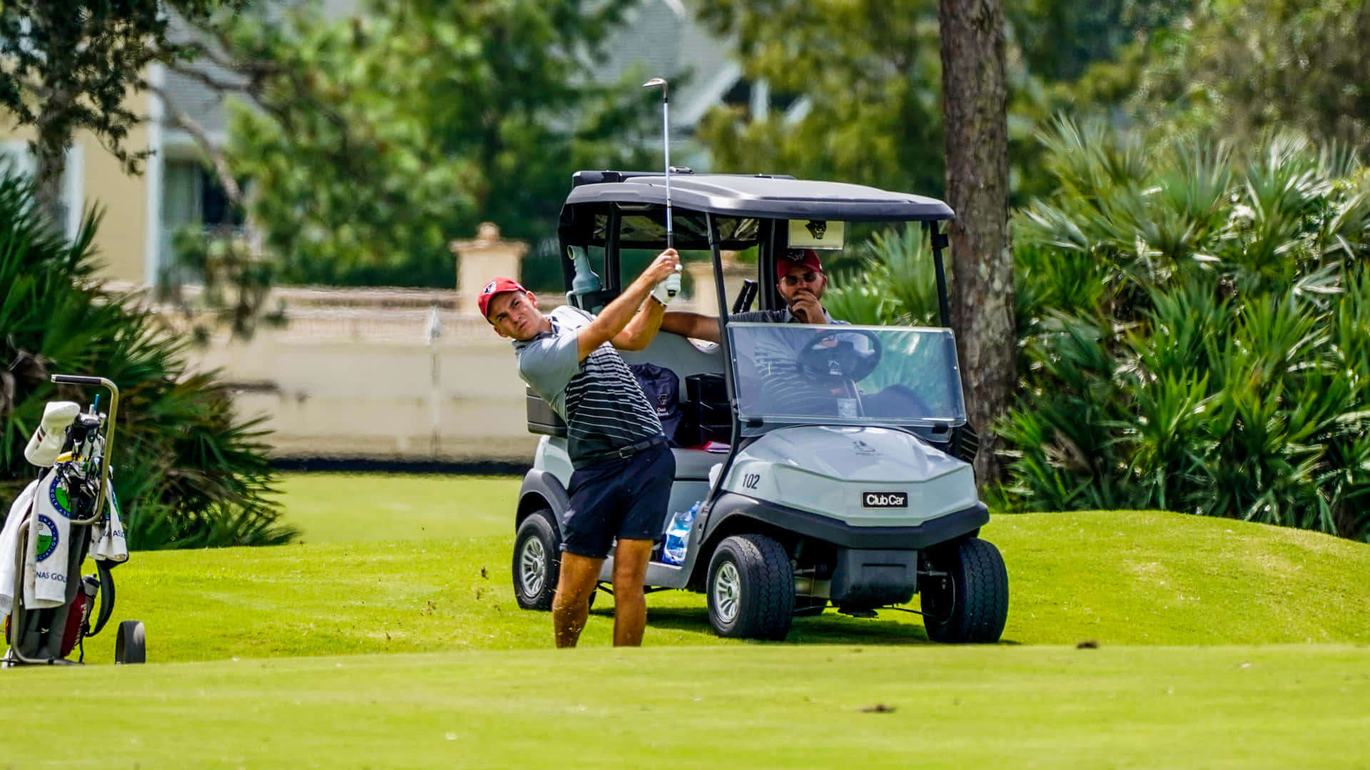 A Man Is Playing Golf With A Golf Cart Background