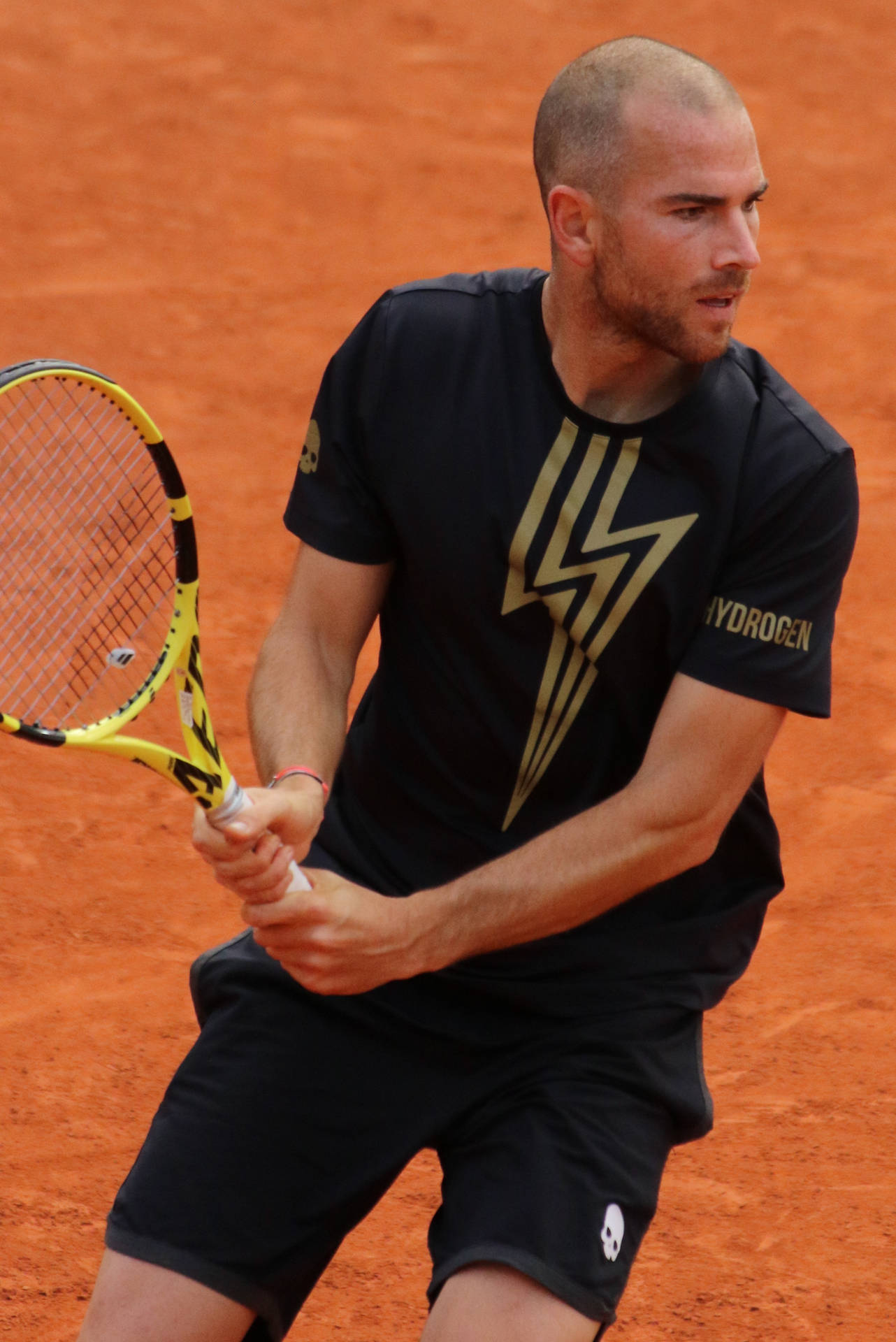 A Man Is Playing Tennis On A Clay Court