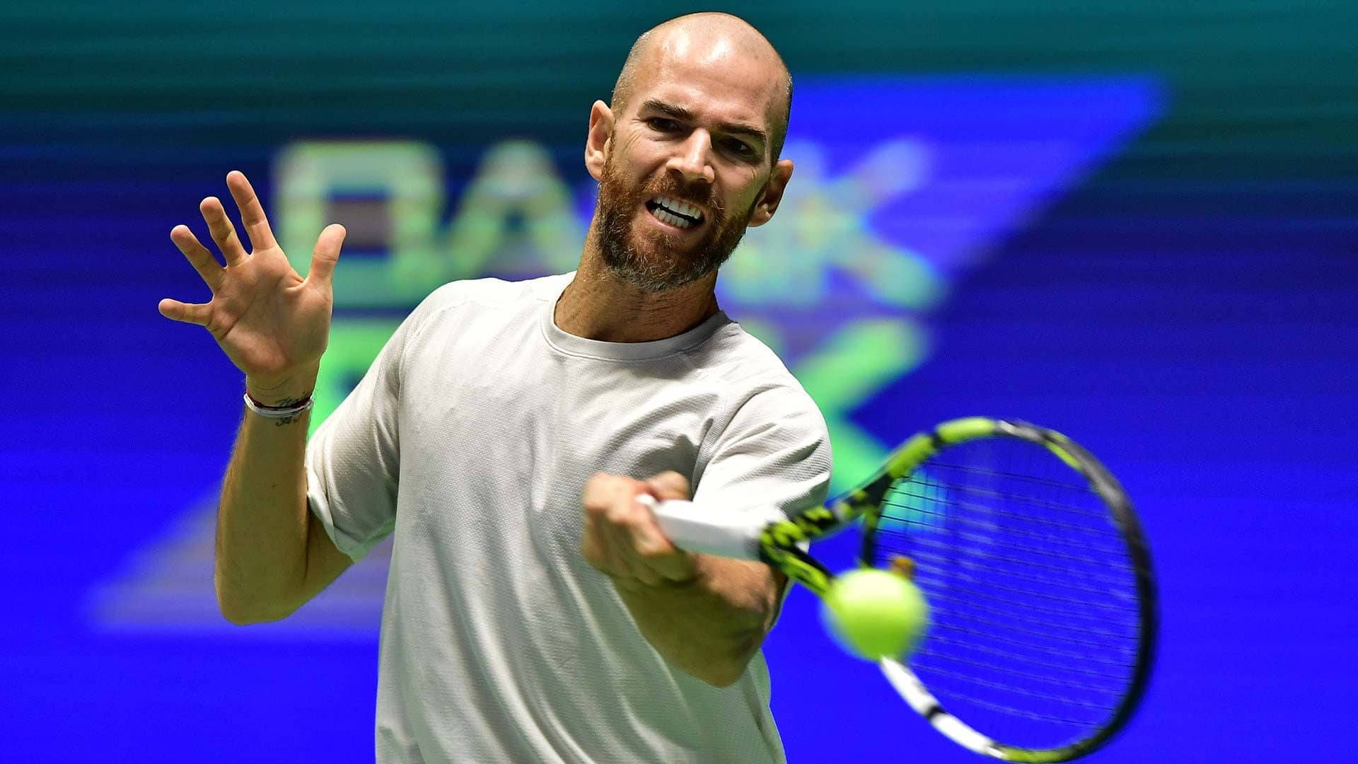 A Man Is Playing Tennis On A Stage Background