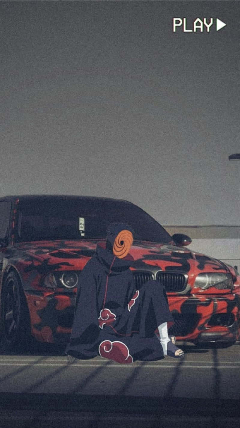 A Man Is Sitting On The Ground Next To A Red Car Background