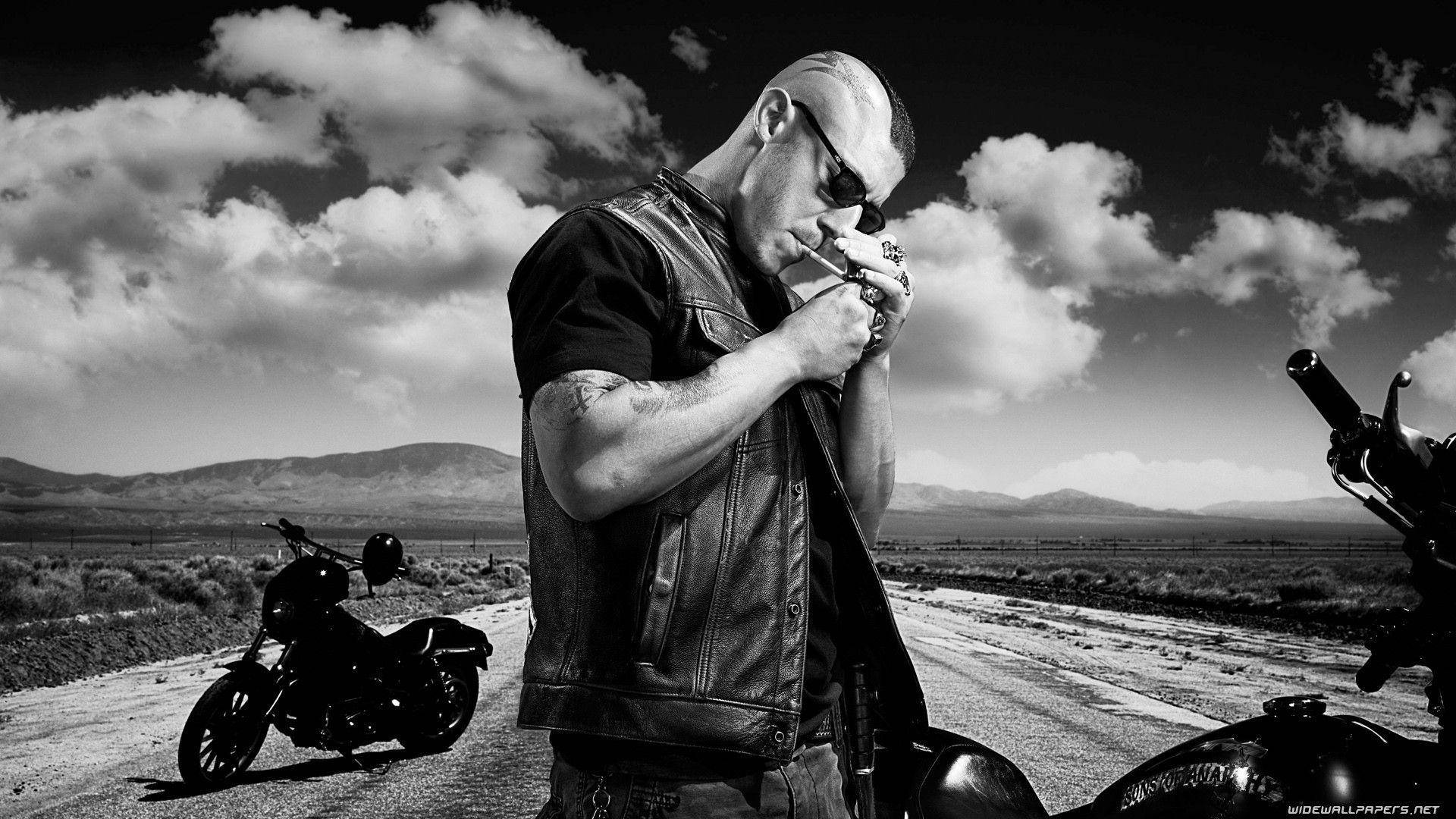 A Man Is Smoking A Cigarette On A Motorcycle Background