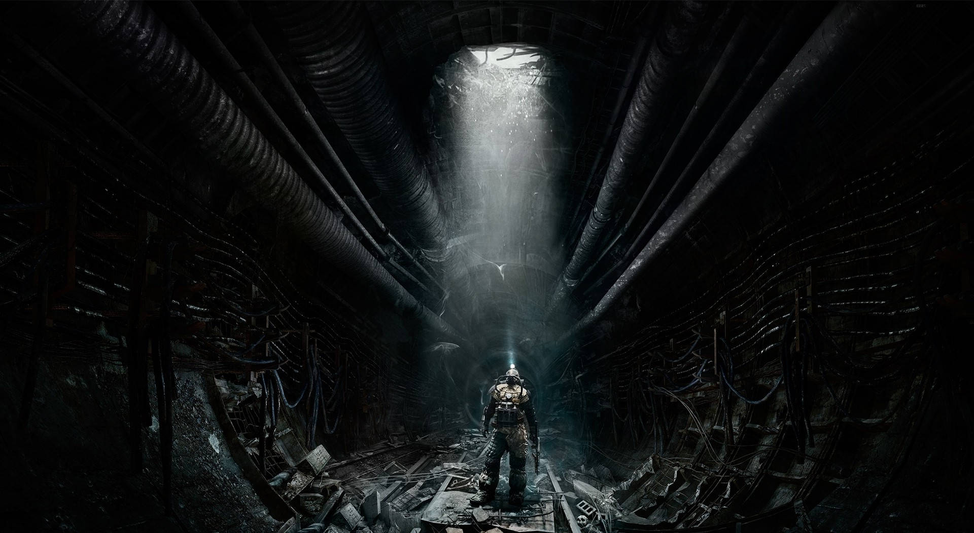 A Man Is Standing In A Dark Tunnel With A Light Shining Through Background