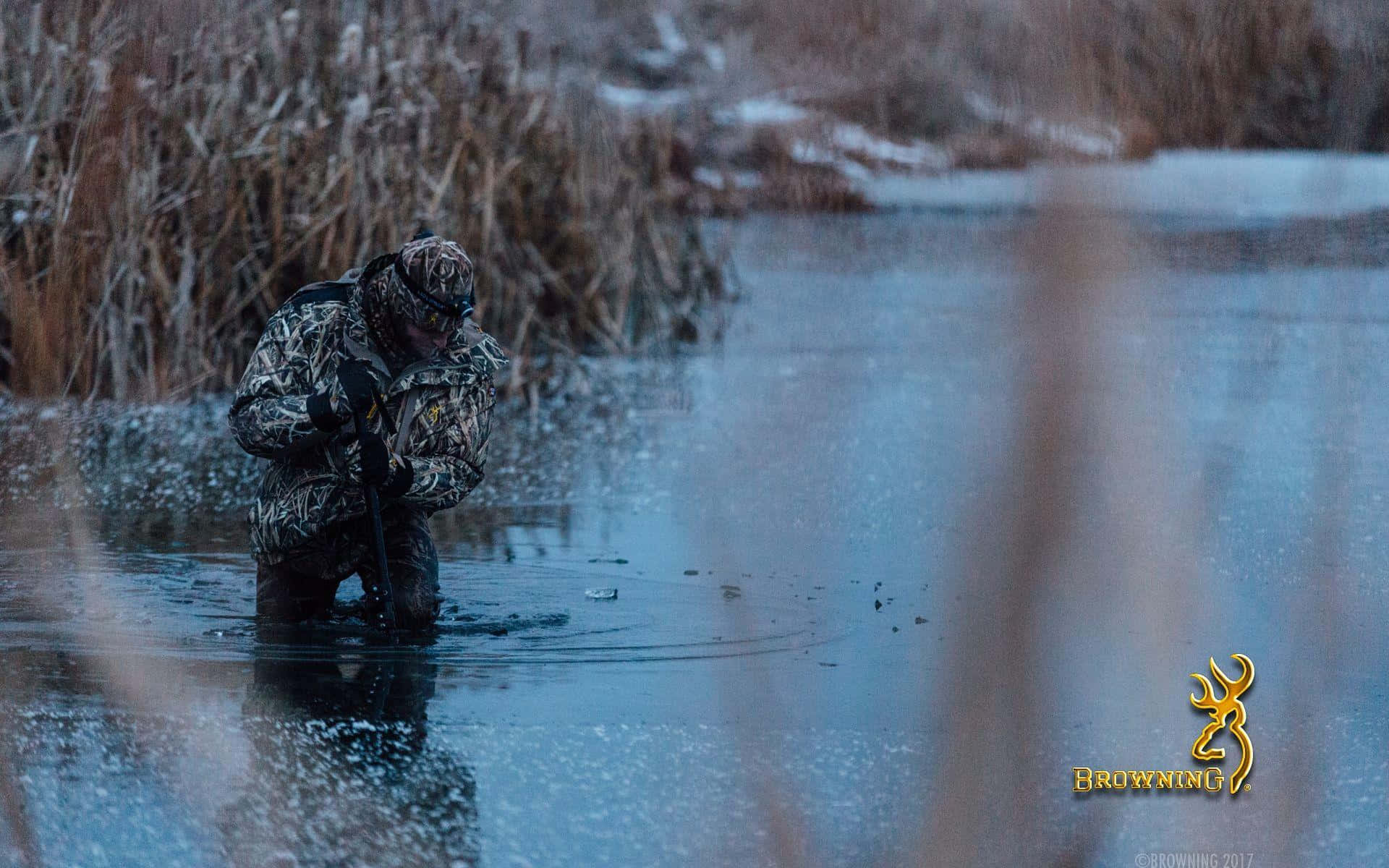 A Man Is Standing In A Pond With Reeds Background