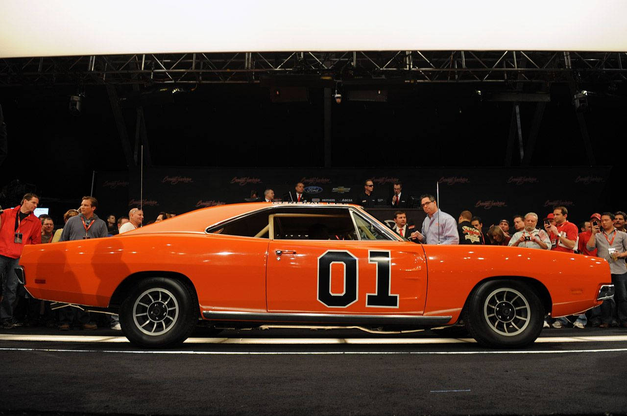 A Man Is Standing In Front Of A Car