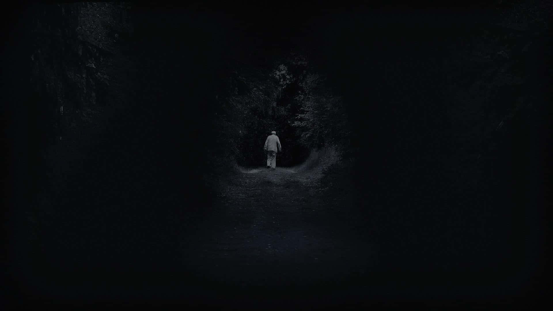 A Man Is Standing In The Dark In A Dark Tunnel Background