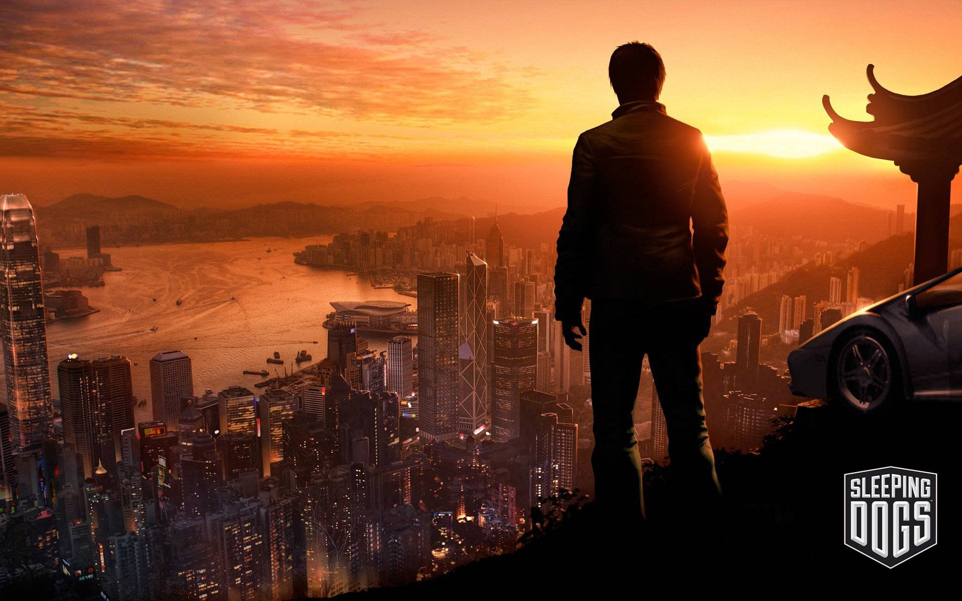 A Man Is Standing On A Hill Overlooking A City At Sunset Background