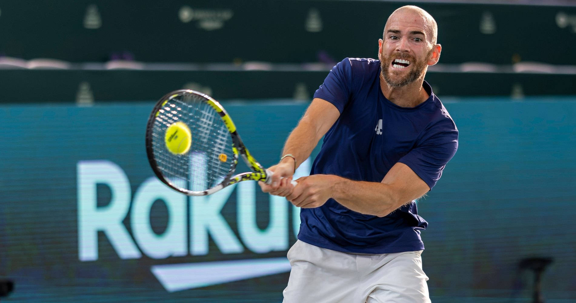 A Man Is Swinging A Tennis Racket