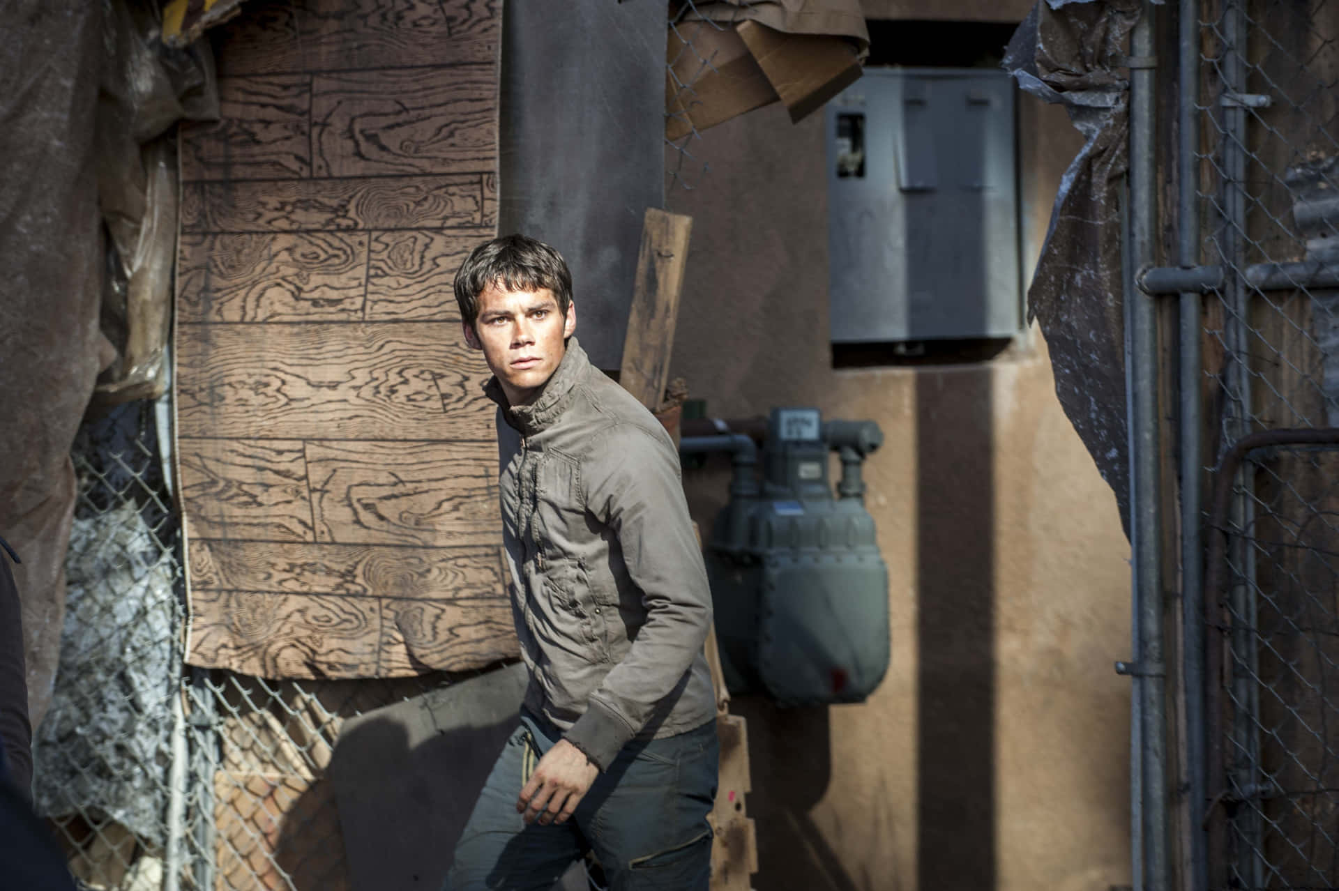 A Man Is Walking Through A Building With A Metal Fence Background