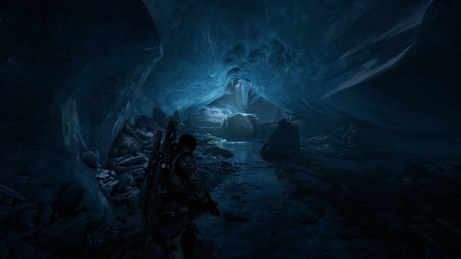 A Man Is Walking Through An Icy Cave Background