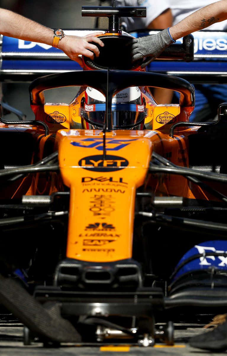 A Man Is Working On The Front Of A Racing Car Background