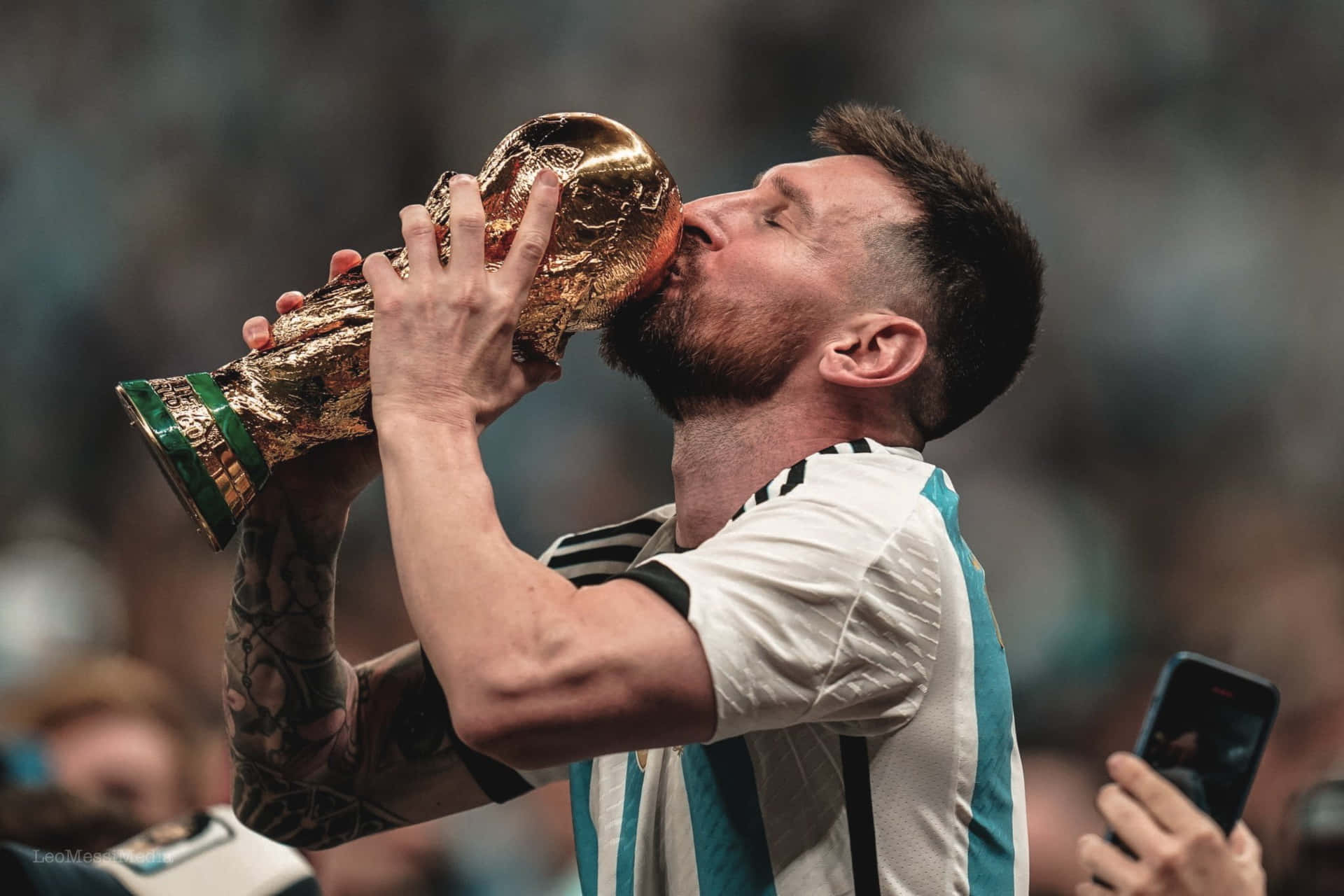 A Man Kissing The Trophy With His Hands Background