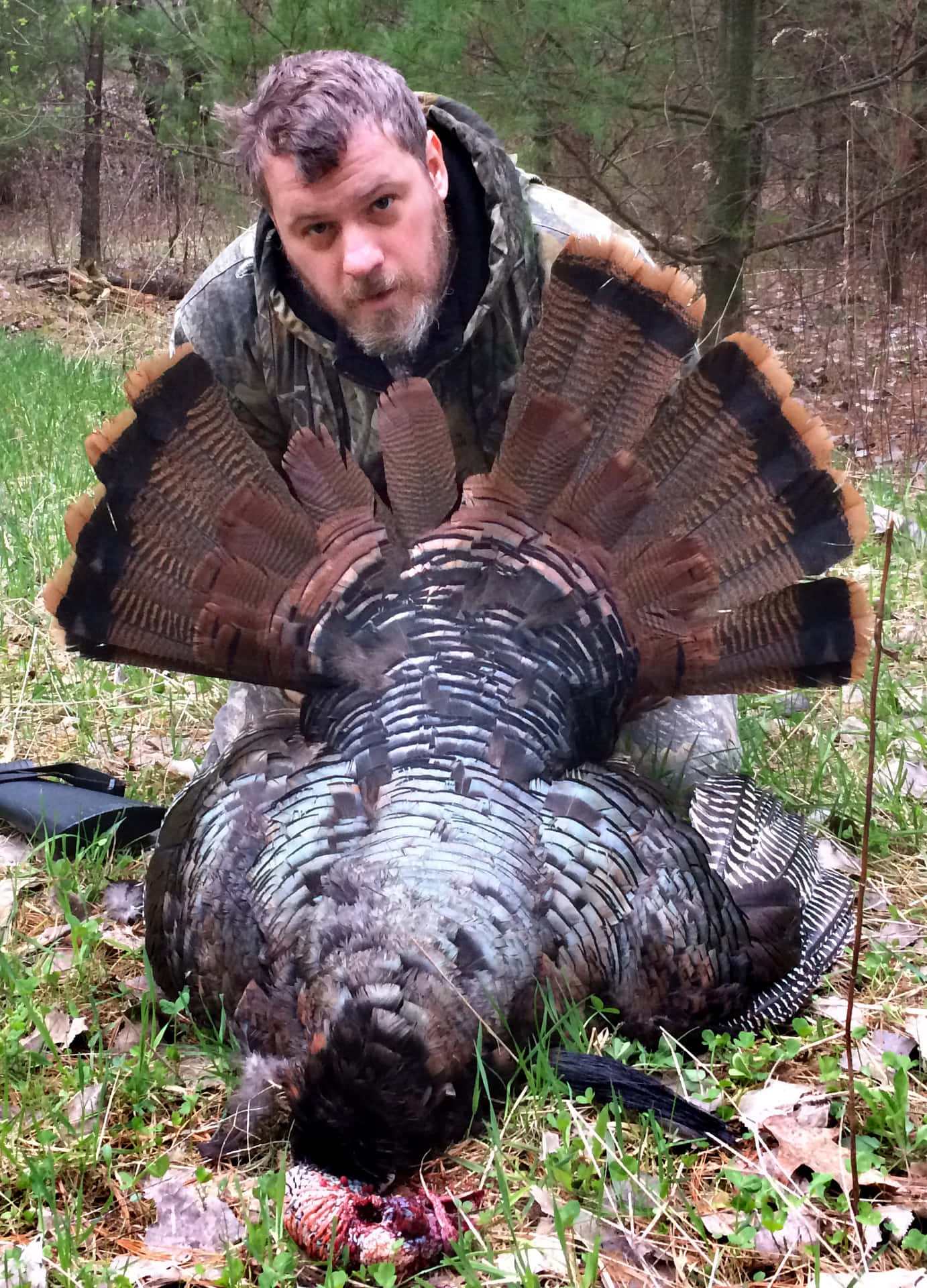 A Man Kneeling Down Next To A Turkey