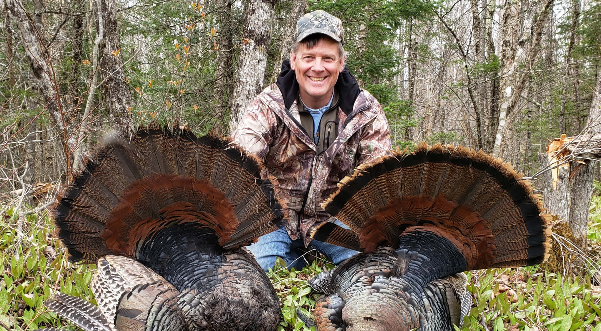 A Man Kneeling Down With Two Turkeys Background