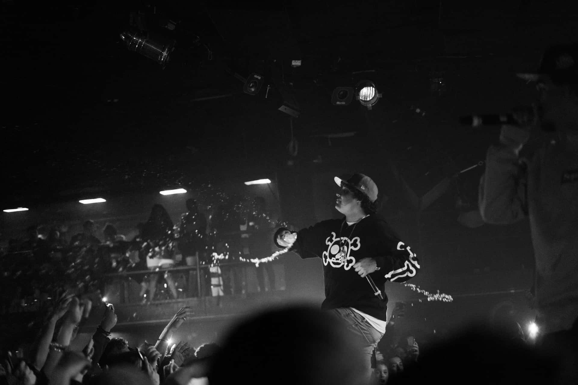 A Man On Stage With A Microphone Background