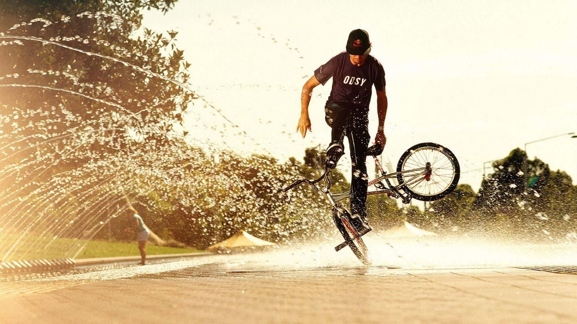 A Man Riding A Bike In The Water