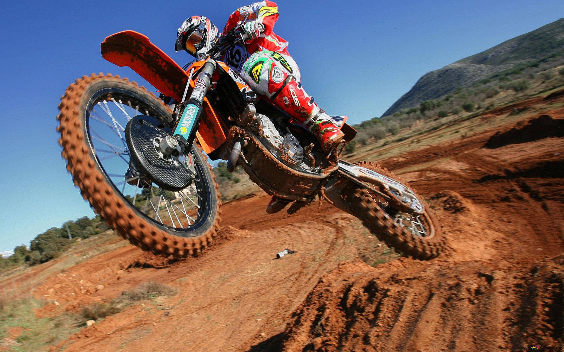 A Man Riding A Dirt Bike Background