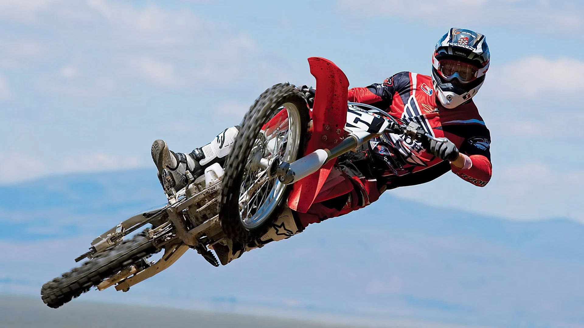 A Man Riding A Dirt Bike Background