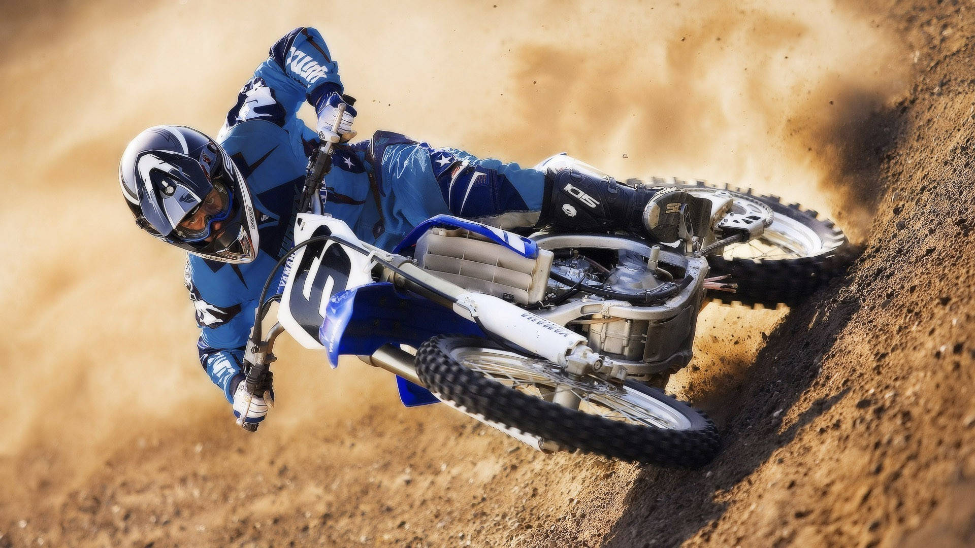 A Man Riding A Dirt Bike On A Dirt Track Background