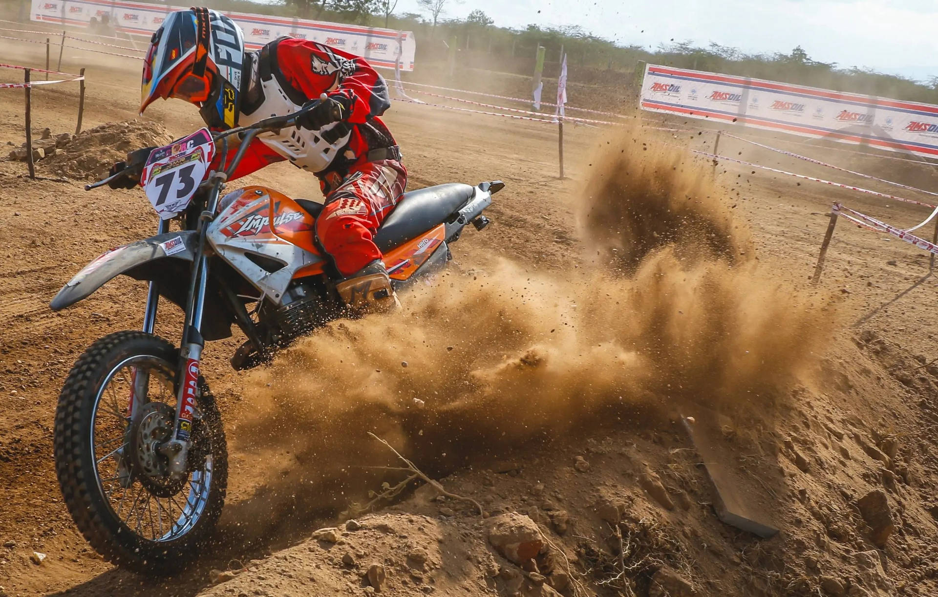 A Man Riding A Dirt Bike On A Dirt Track Background