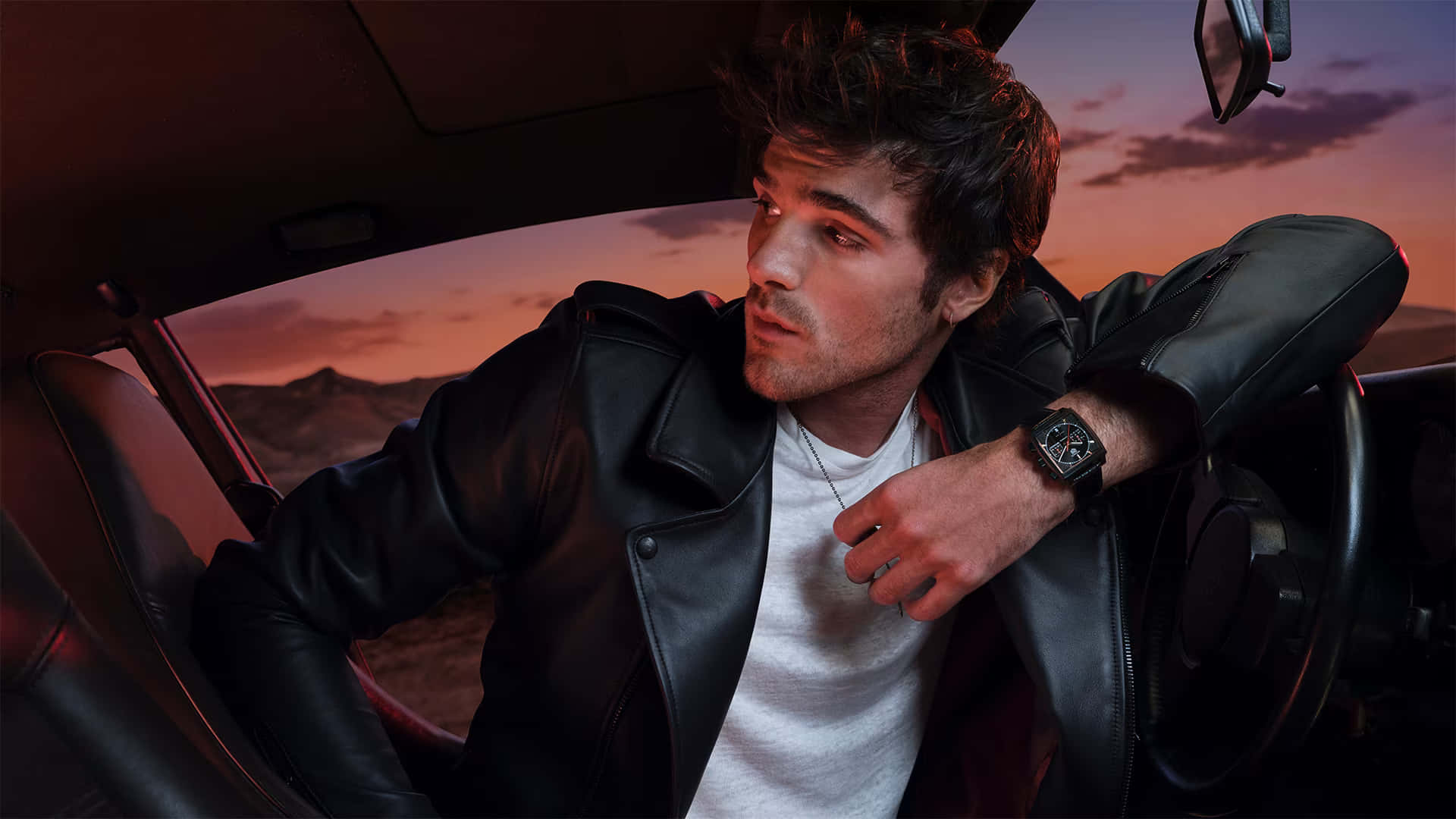 A Man Sitting In A Car With His Watch On Background