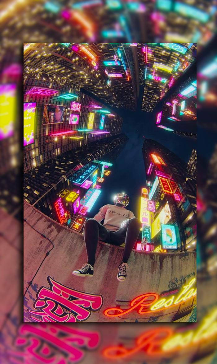 A Man Sitting On A Ledge In Front Of Neon Lights Background