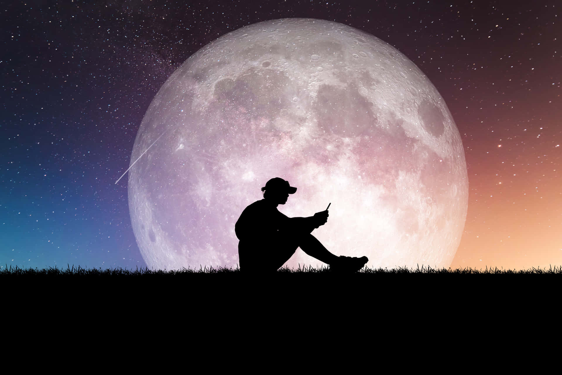 A Man Sitting On The Ground With A Full Moon Behind Him Background