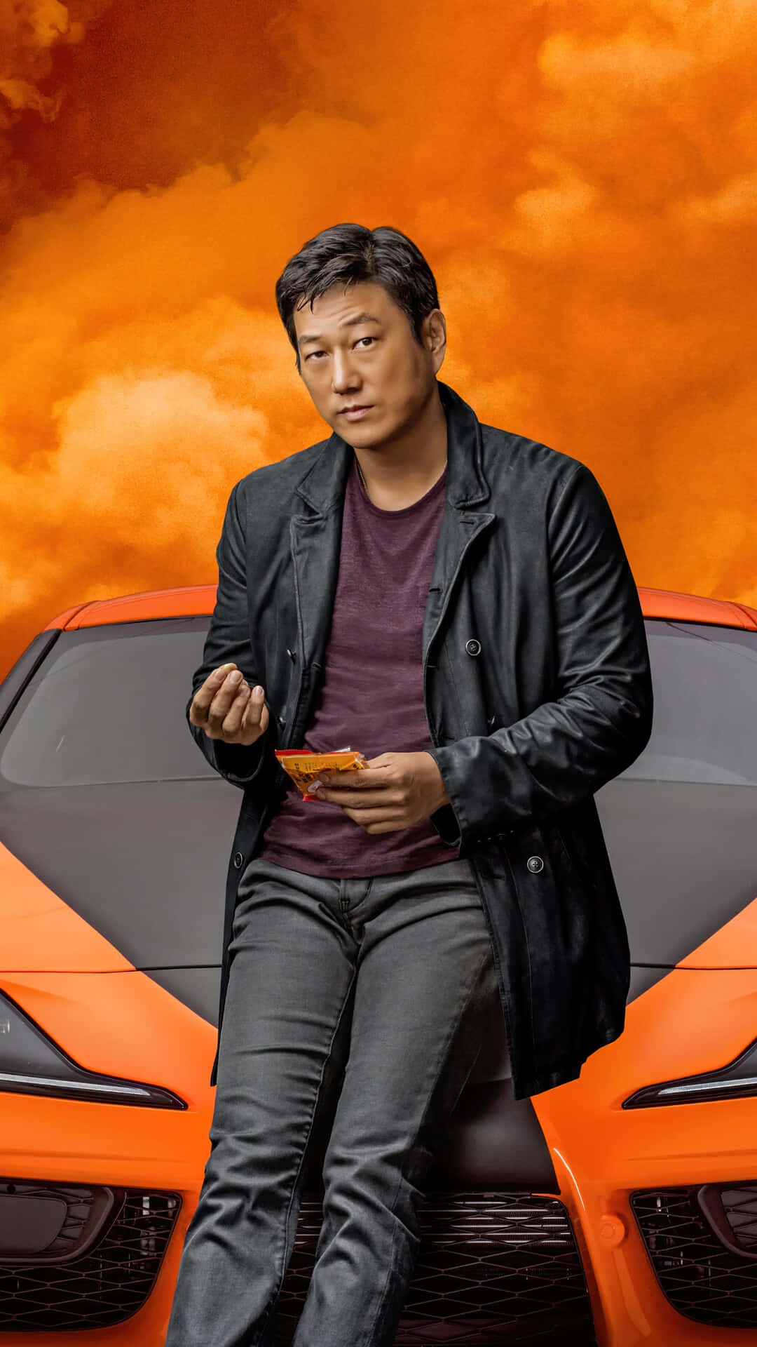 A Man Sitting On Top Of A Sports Car Background