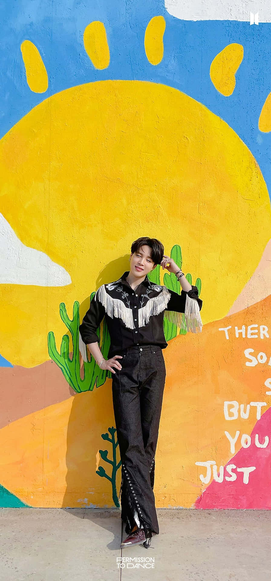 A Man Standing In Front Of A Colorful Wall