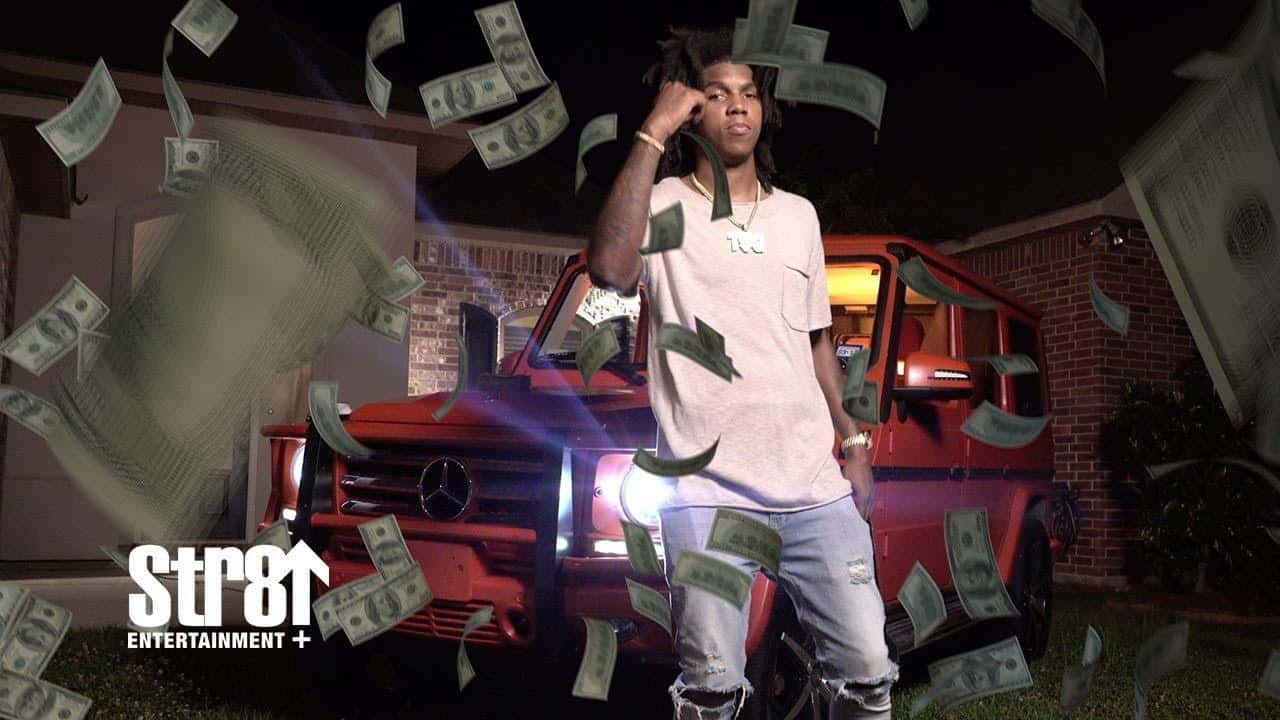 A Man Standing In Front Of A Red Truck With Money Falling From It Background