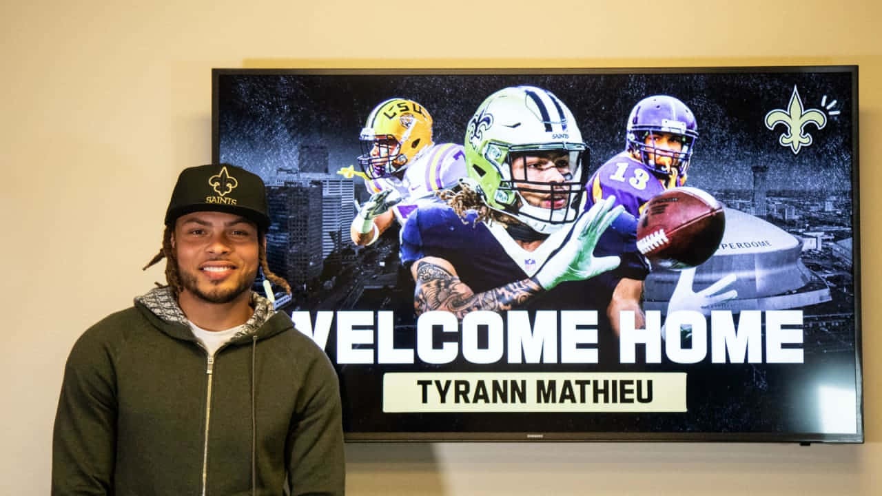 A Man Standing In Front Of A Tv With The Words Welcome Home Background