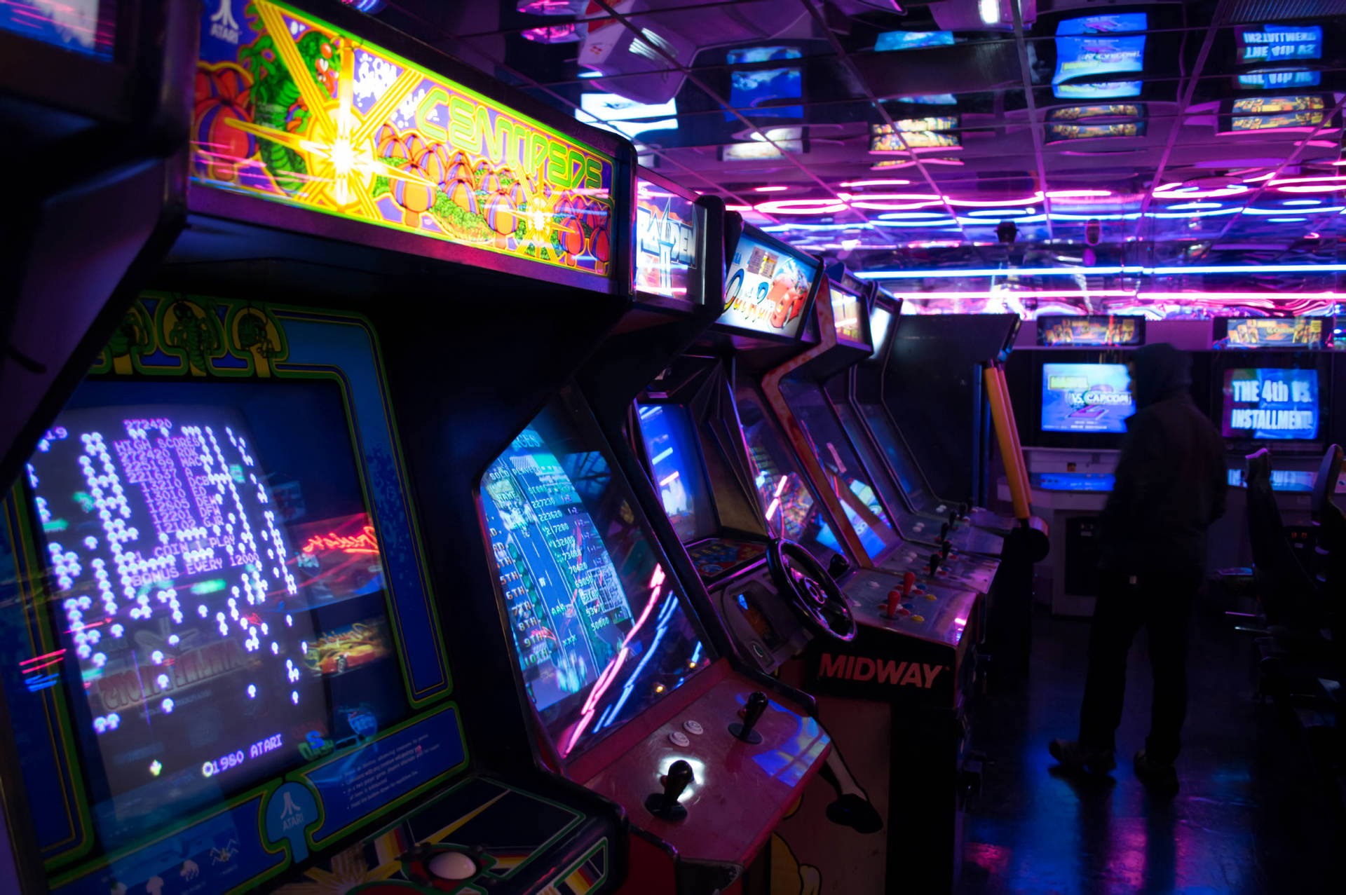 A Man Standing In Front Of A Video Game Room Background