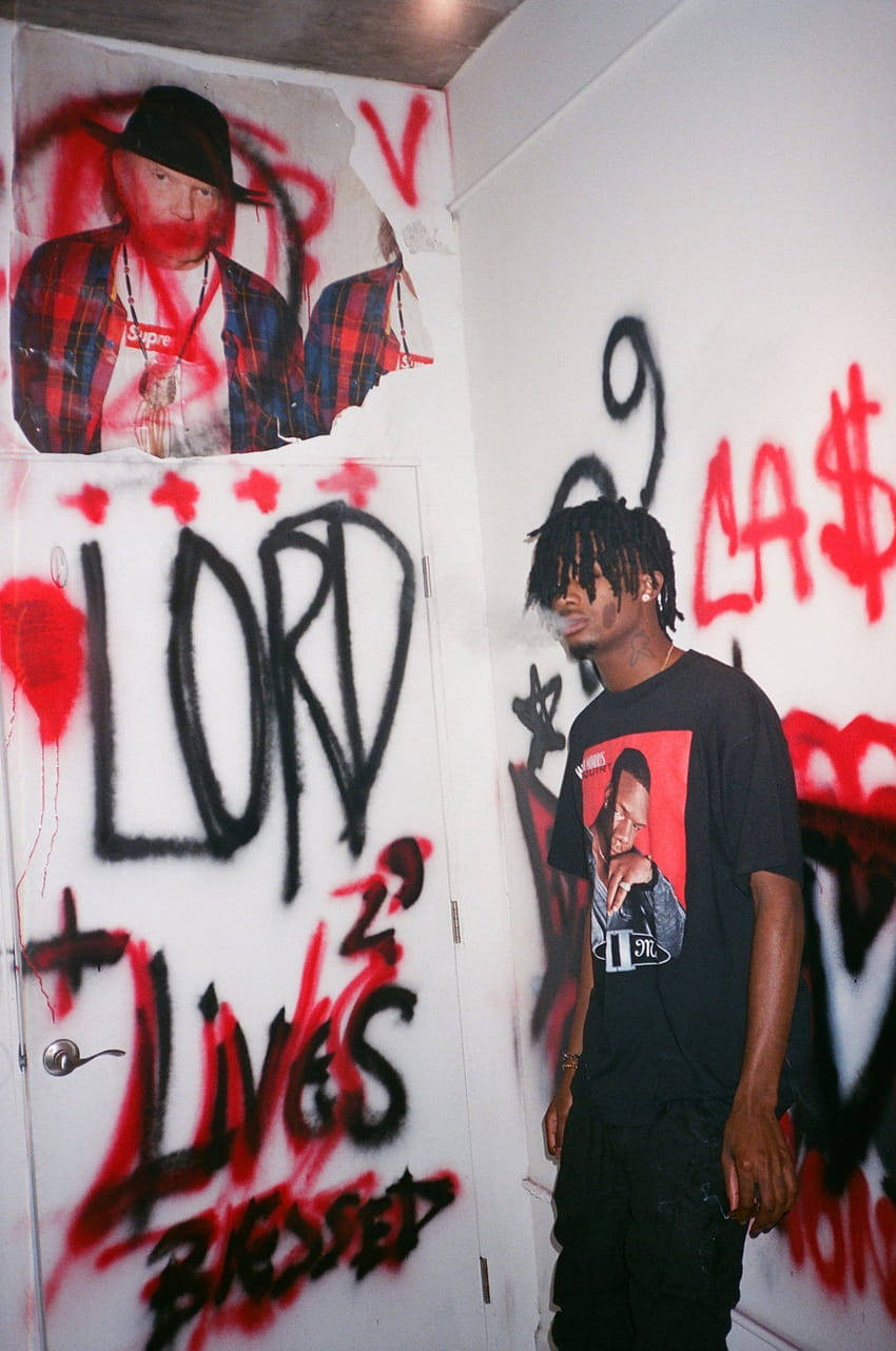 A Man Standing In Front Of A Wall With Graffiti Background