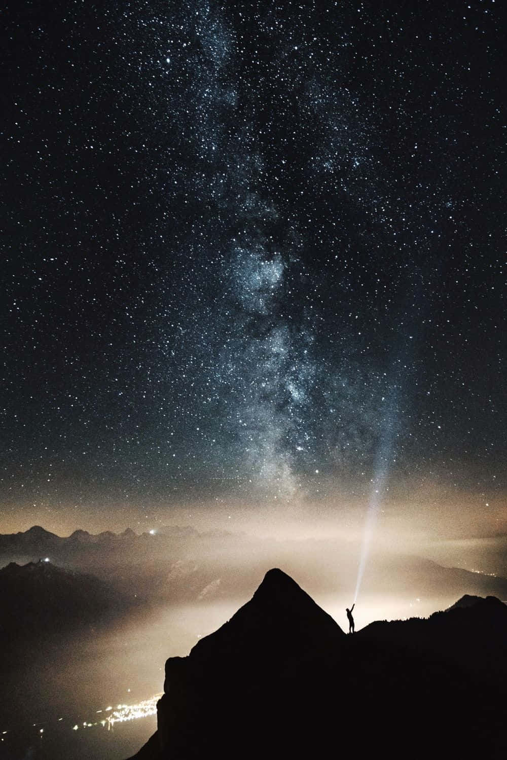 A Man Standing On A Mountain Top With The Milky Way Above Him